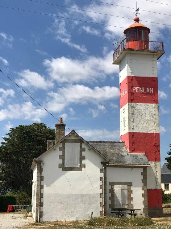 an old lighthouse is next to a very tall white building