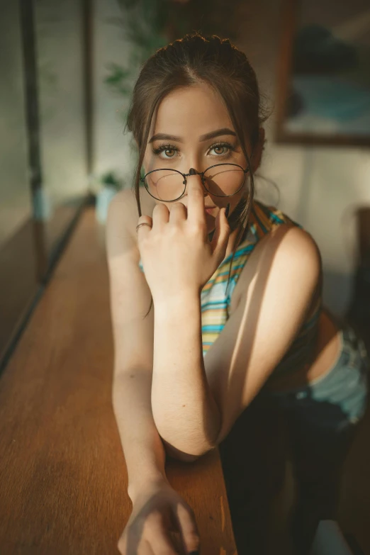 a woman is sitting at a table with her hand on her mouth