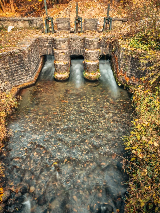 a small well is surrounded by green grass