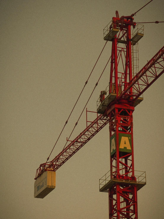 two different sized and colored construction cranes