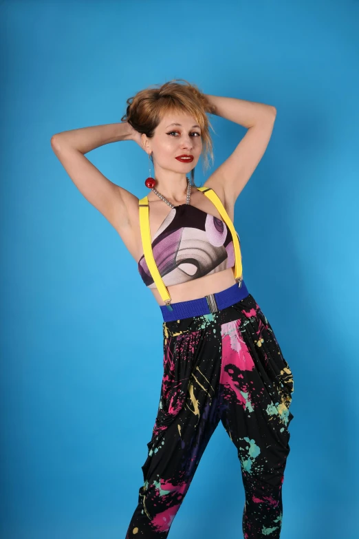 a model posing with her hair in a bun with bright colored clothes