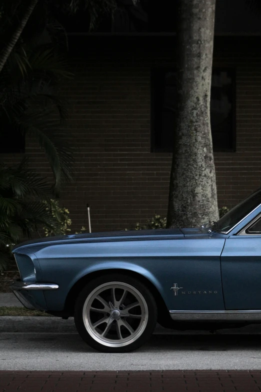 a blue mustang car parked by the curb