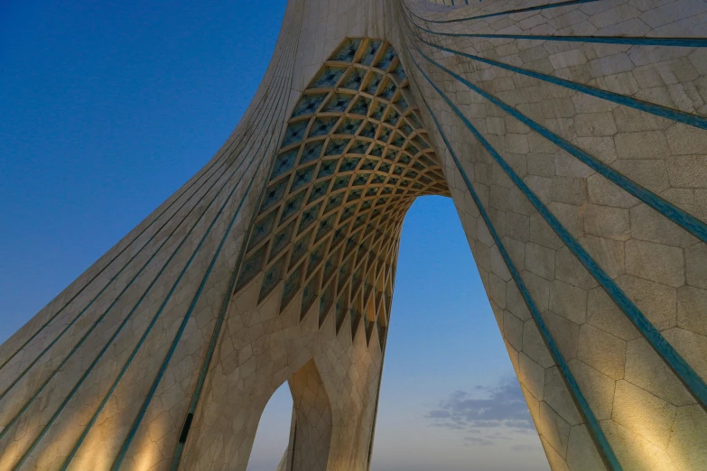 two people walking under a long structure at dusk