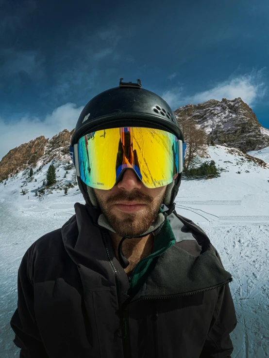 a man with ski goggles and a helmet on his head in the snow