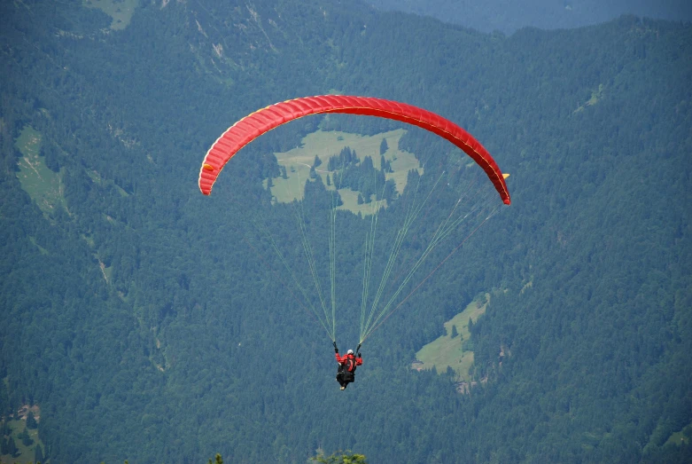 an image of a person para sailing in the mountains