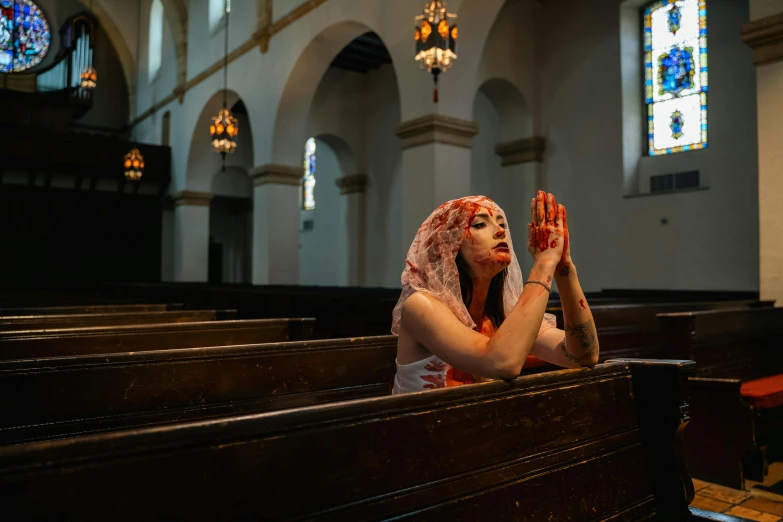 a woman sitting in the pew while she is holding her hands