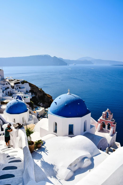 a blue domed church by the ocean with a view