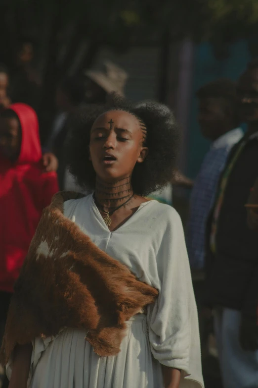 a woman is walking while wearing fur in her hands