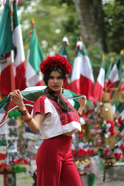 a woman dressed up in red holding a green umbrella