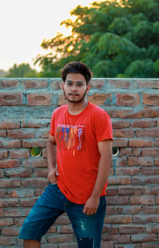 a man standing in front of a wall with brick