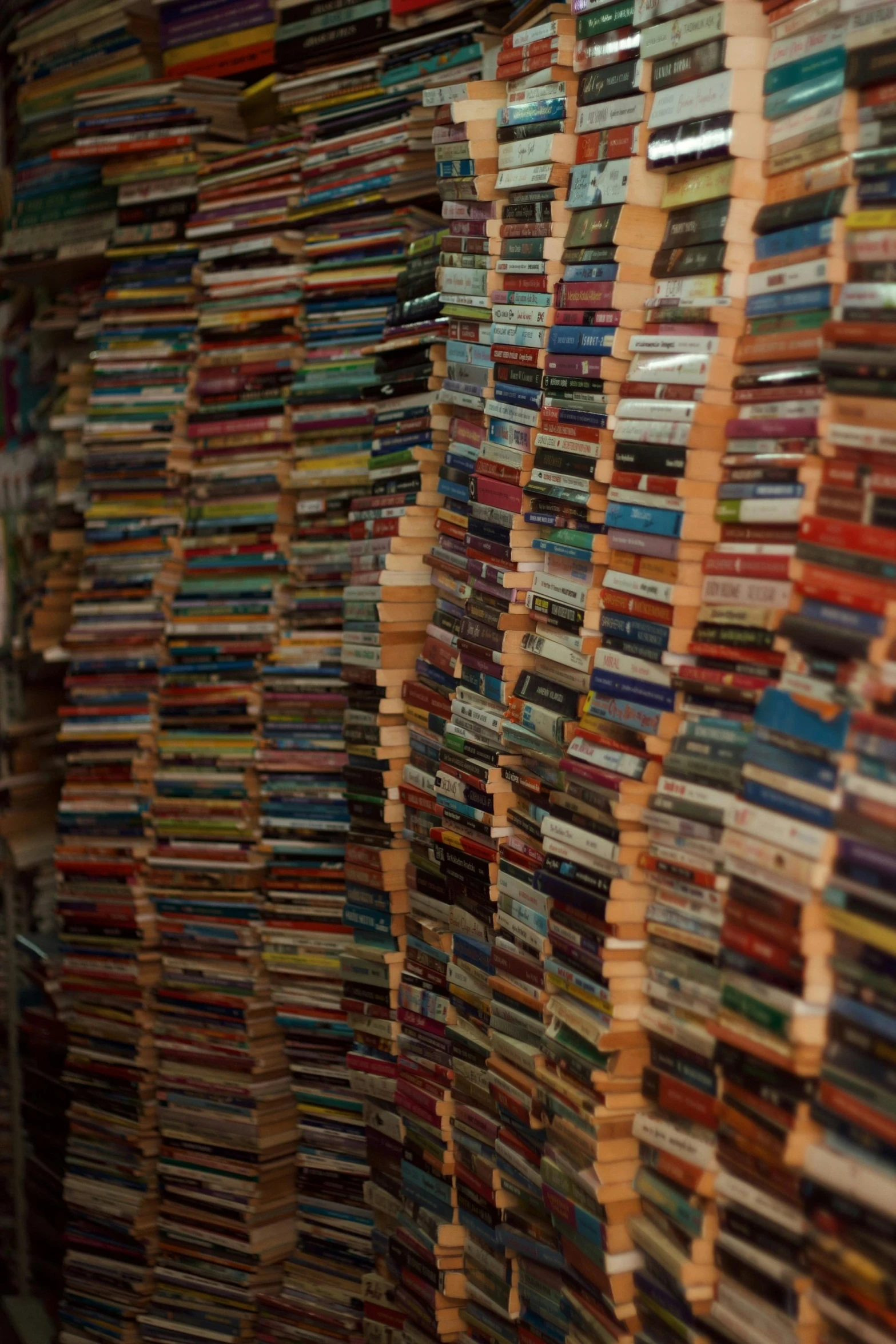 a large number of books are stacked up on a wall