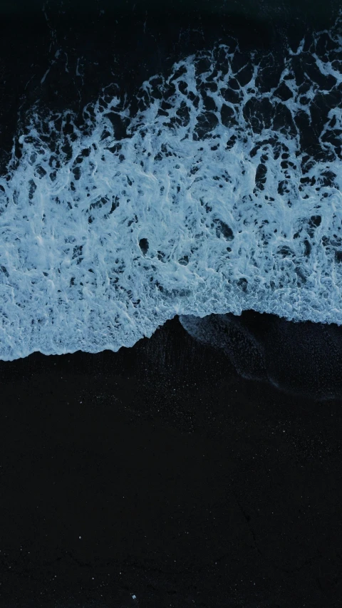 some black sand water and waves crashing in