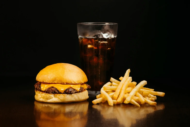 a hamburger, fries, and drink on a table