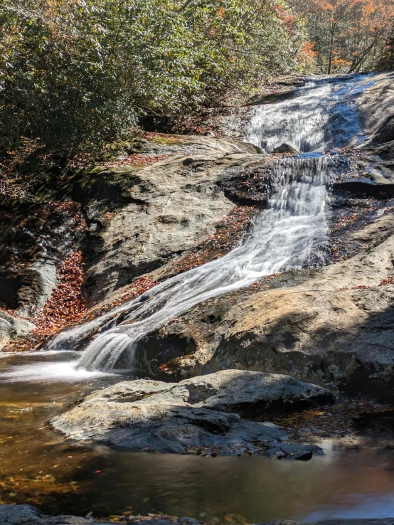 an image of waterfall in fall setting with leaves