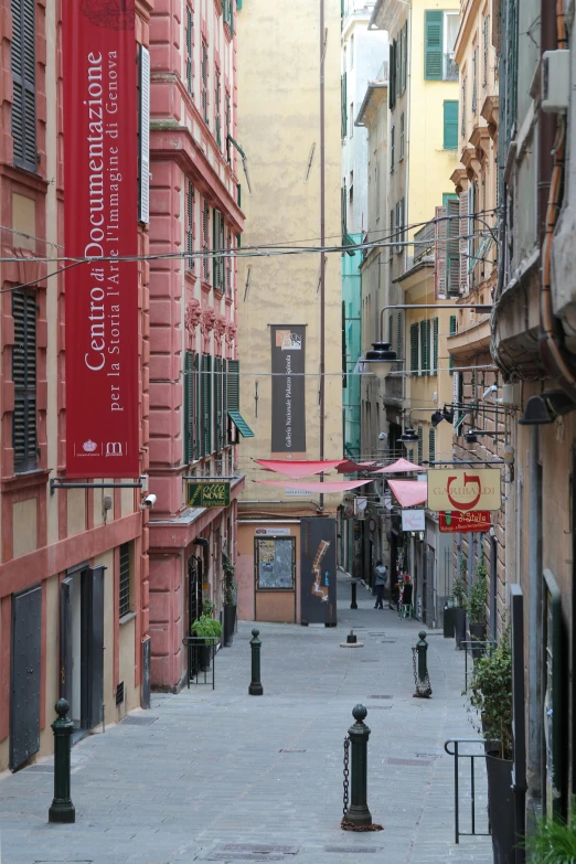 a city alley is marked with a large red banner