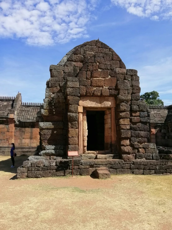 a person is walking in front of an ancient structure