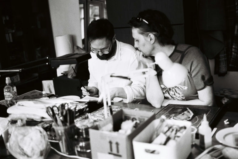 a man and woman sitting at a table with food in front of them