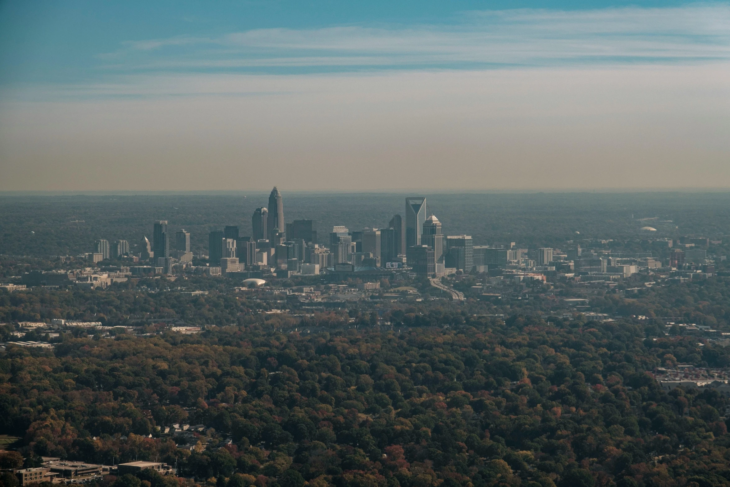 view of large cityscape from air with blue sky