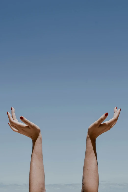 an open pair of hands reaching up into the sky