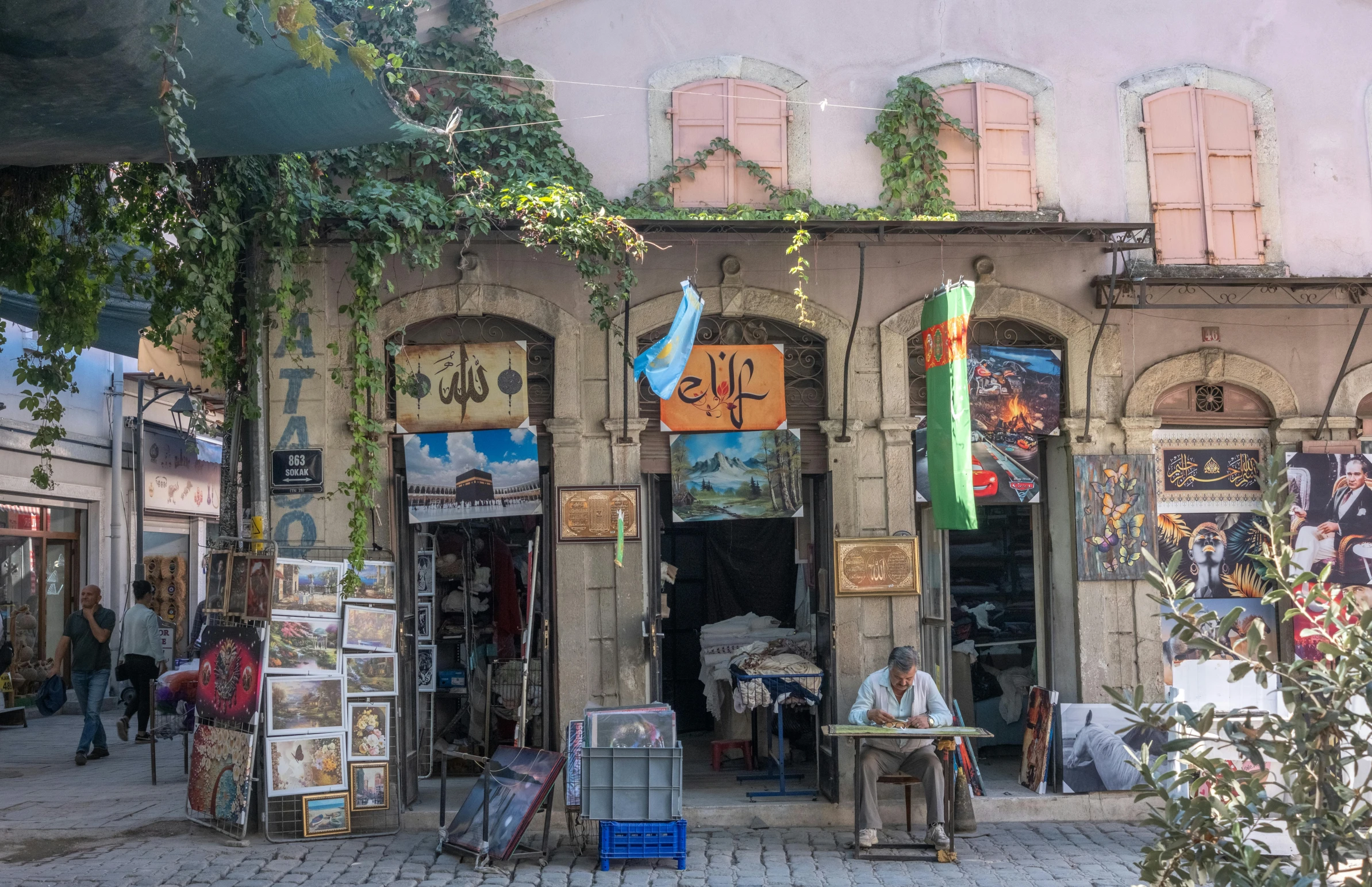 a woman sits outside of a small shop