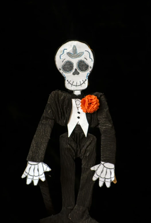 a skeleton in a tuxedo, with one flower pinned on its shoulder