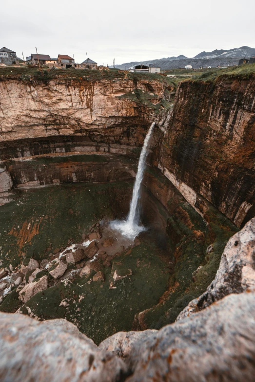 a man flying from a large waterfall into a pool