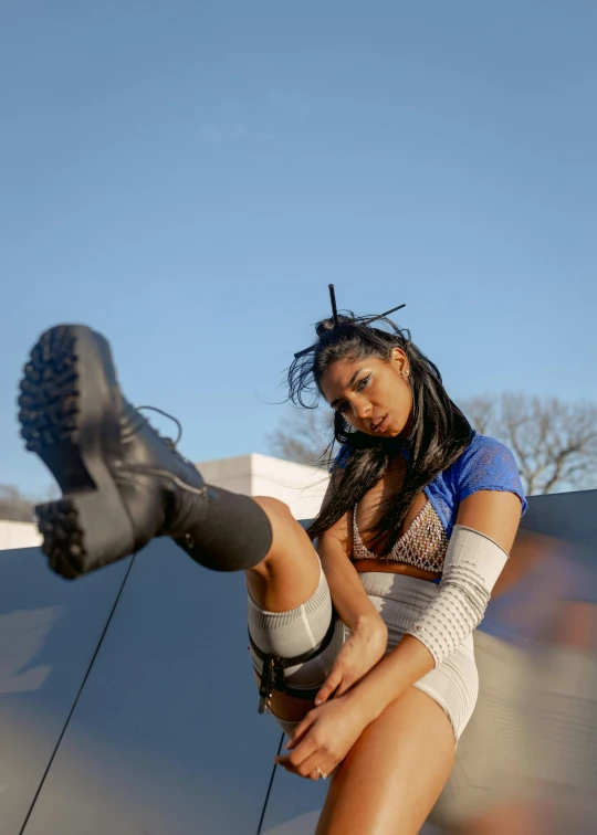 a young woman in a short skirt holding onto the boot of her skateboard