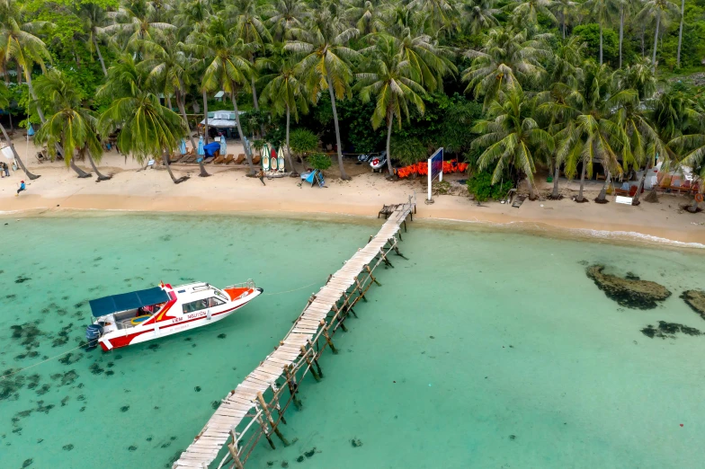 a boat docked on the shore of a tropical beach