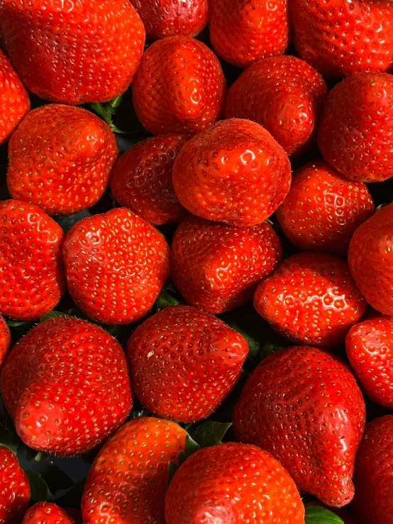 several big strawberries are on display in this image