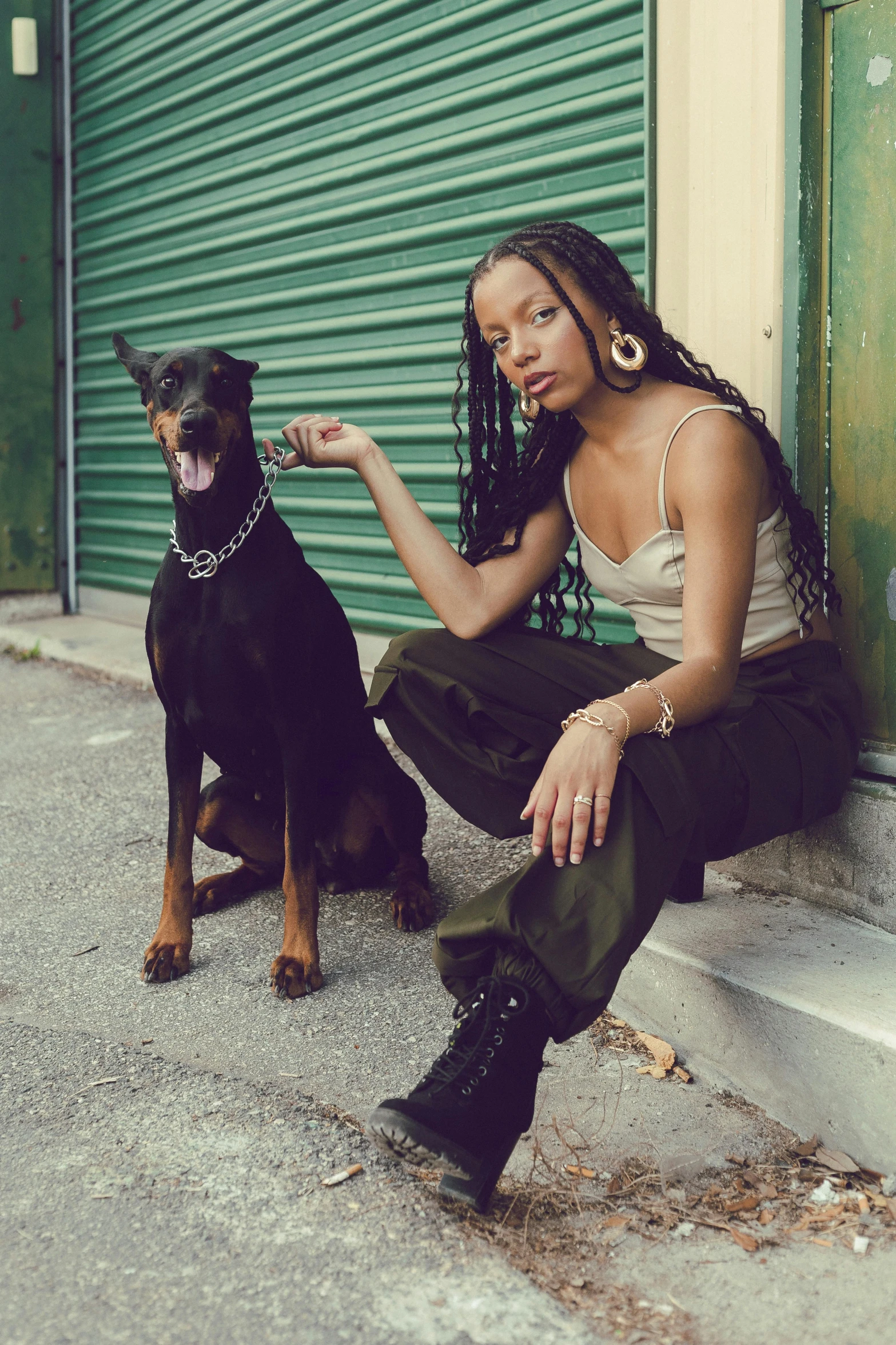 a woman poses next to a black dog