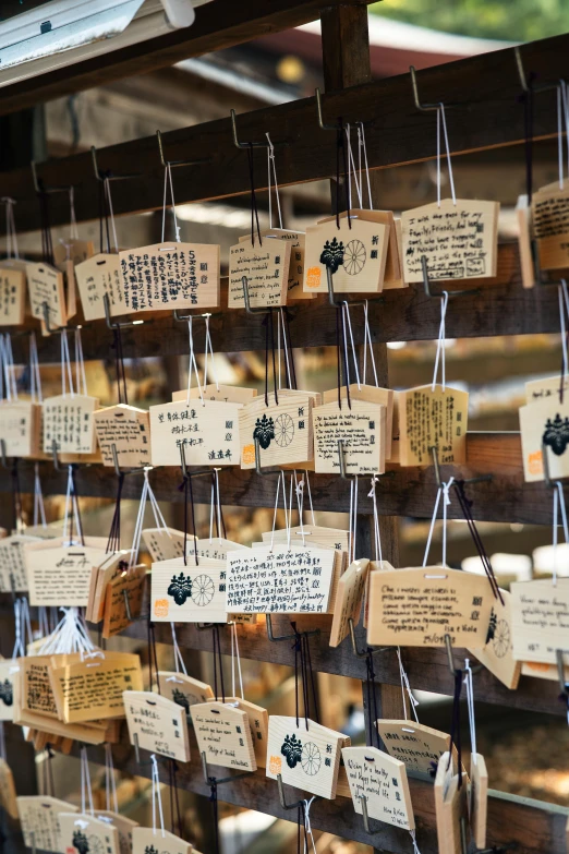 a wooden rack filled with lots of tags and hand written names