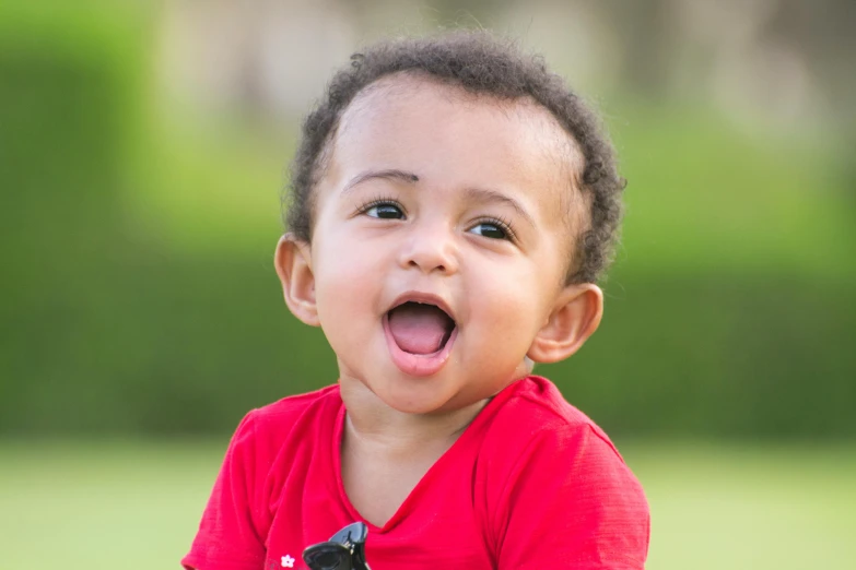 a little boy wearing red is sticking out his tongue