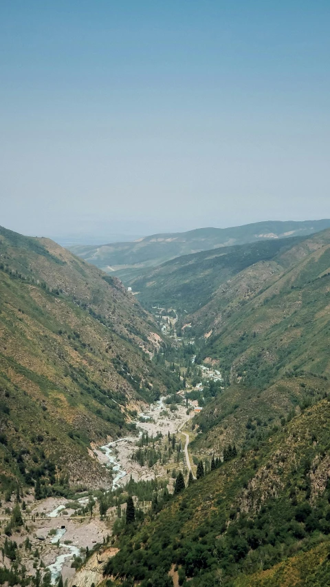 a view of a river surrounded by a lush green hillside