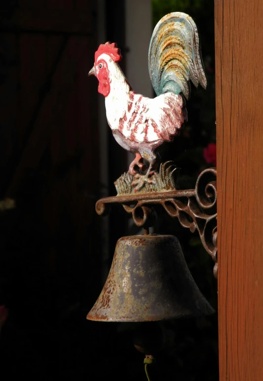 an ornamental bird with a bell attached to it's front
