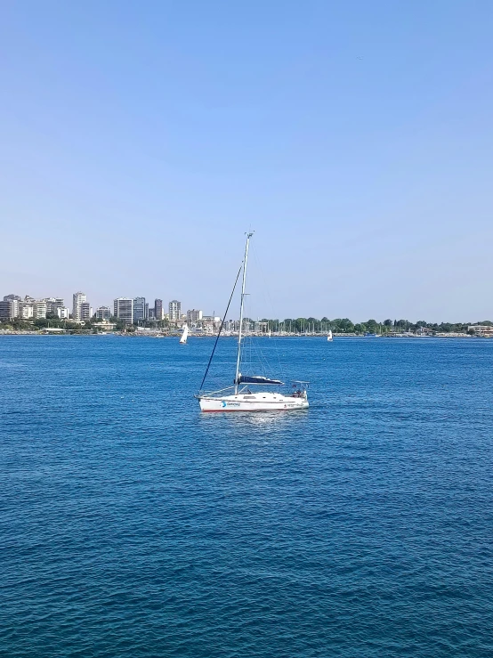 a small boat in the water with some buildings in the background