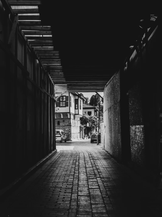 an open dark alley with a brick sidewalk