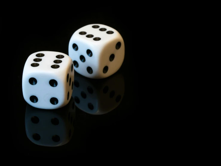 two dice are sitting on a black surface