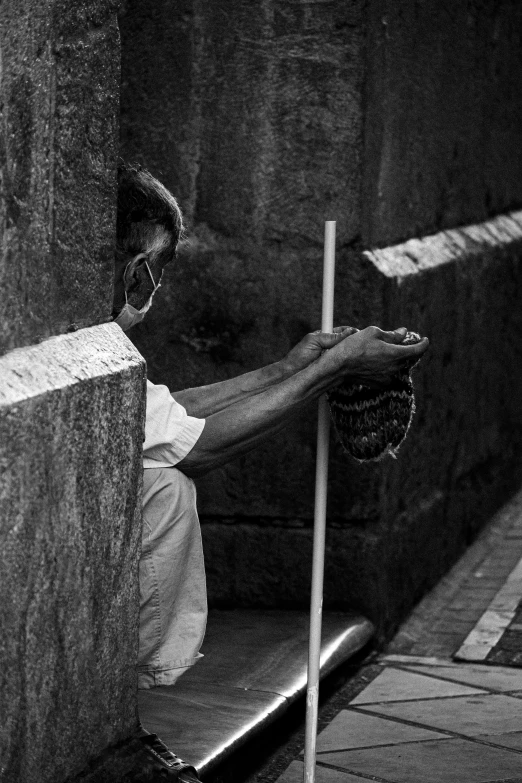 a man sitting at the curb with his back to the ground