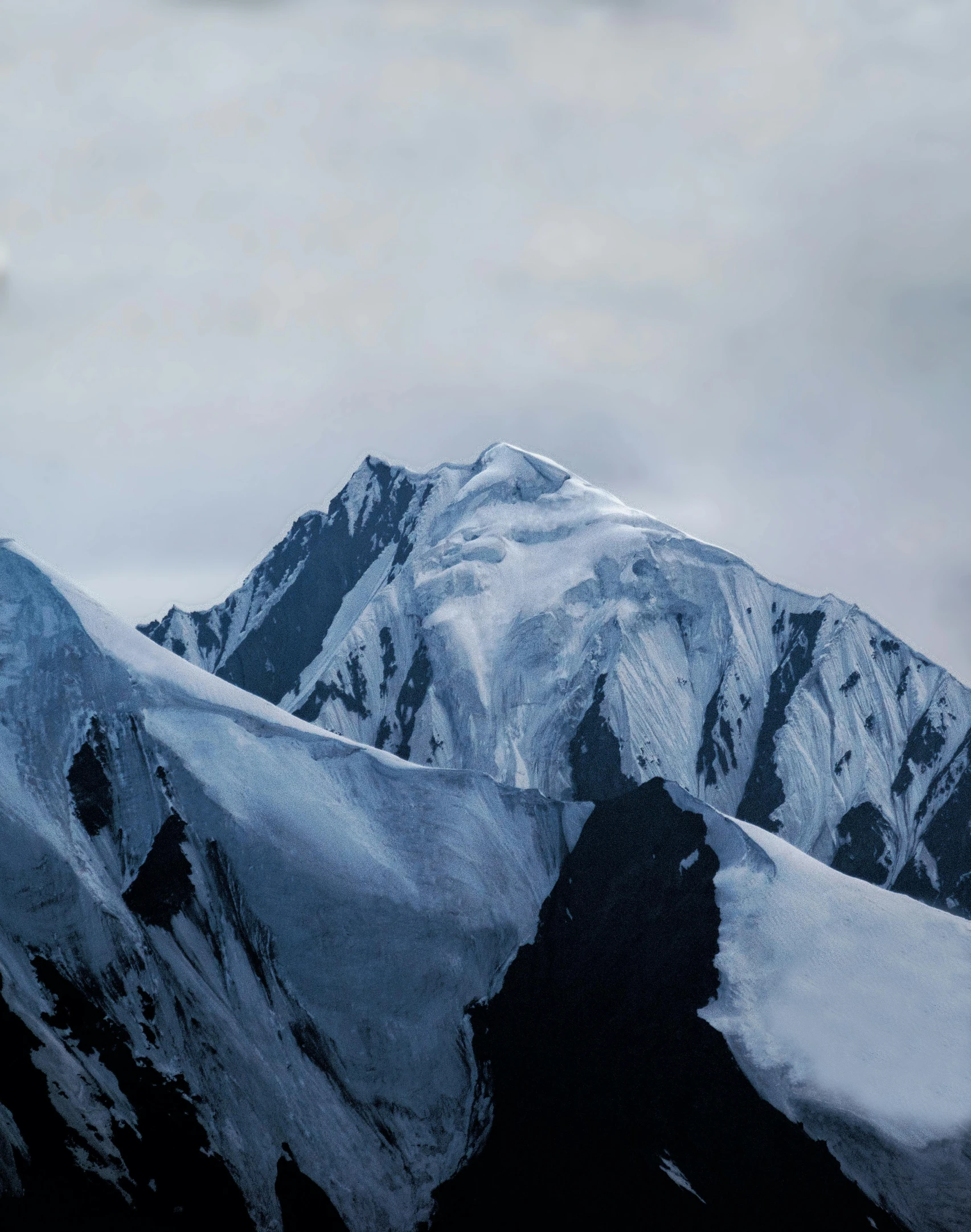 a snow covered mountain with the tops covered in snow