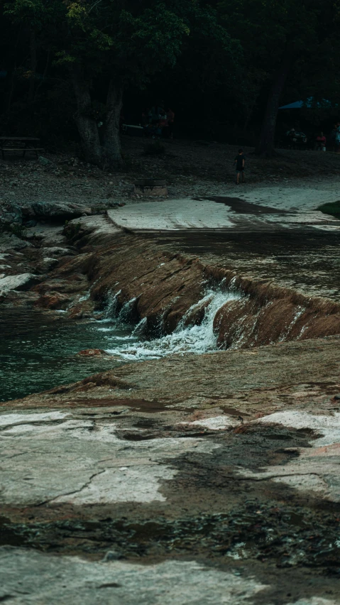 there is water moving over rocks and sand