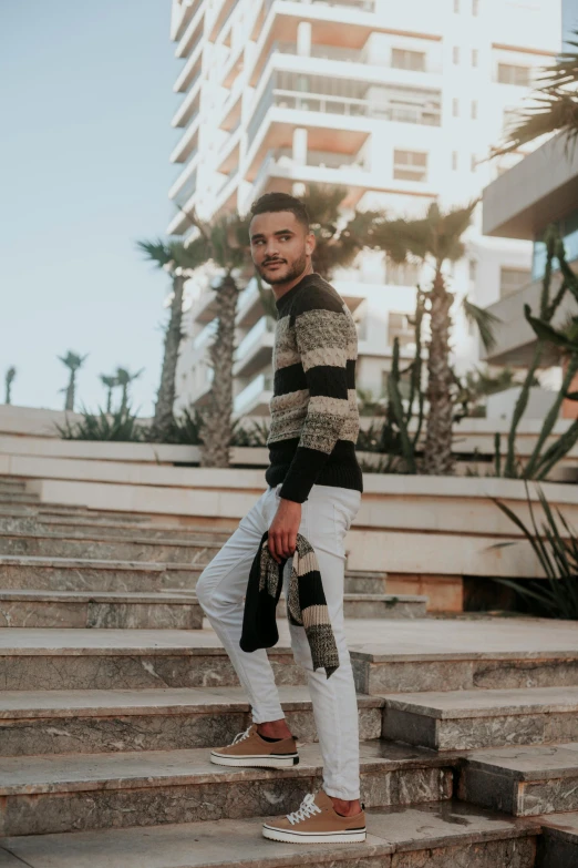 a man standing on some steps with a black and grey shirt