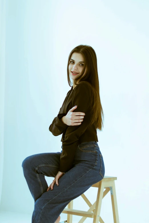 woman posing on a stool with her arms crossed