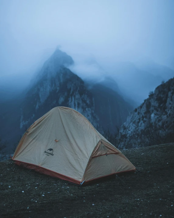 a tent in the wilderness with a mountain in the background