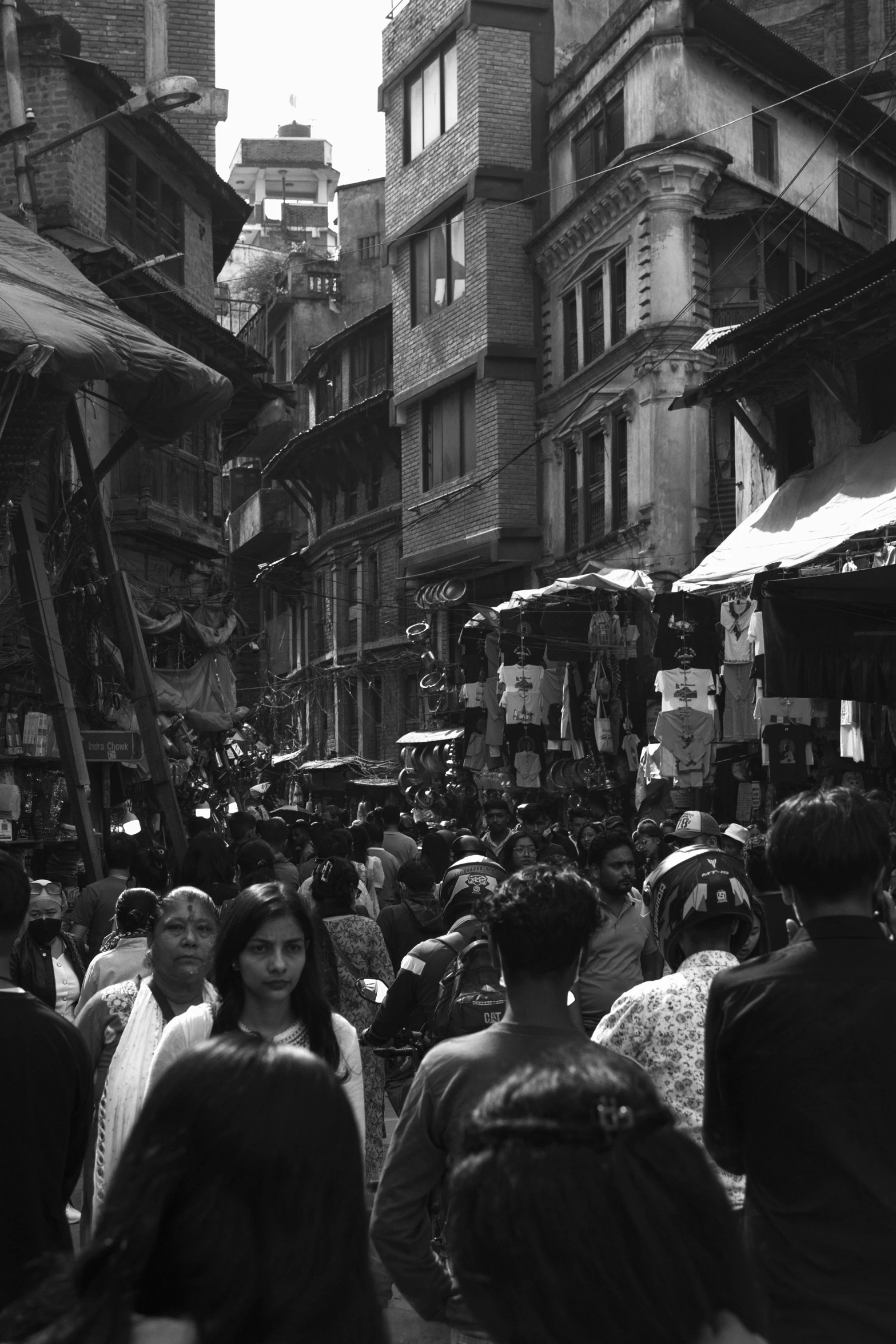 a large group of people walking through an area full of stores