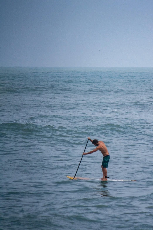 a man holding a paddle while standing in the water