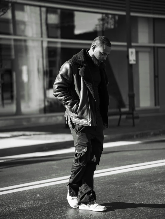 a man is walking down the street in black and white