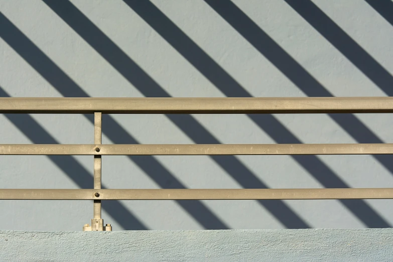 a wooden fence in front of a gray wall