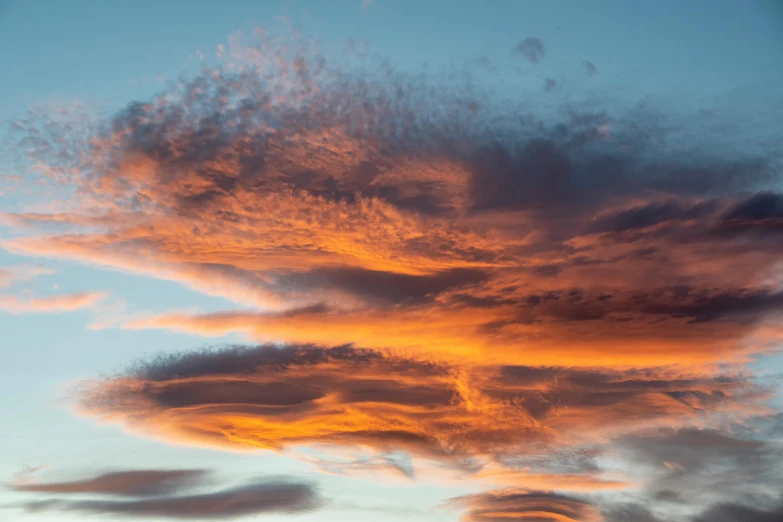 the sky with orange clouds is shown at sunset