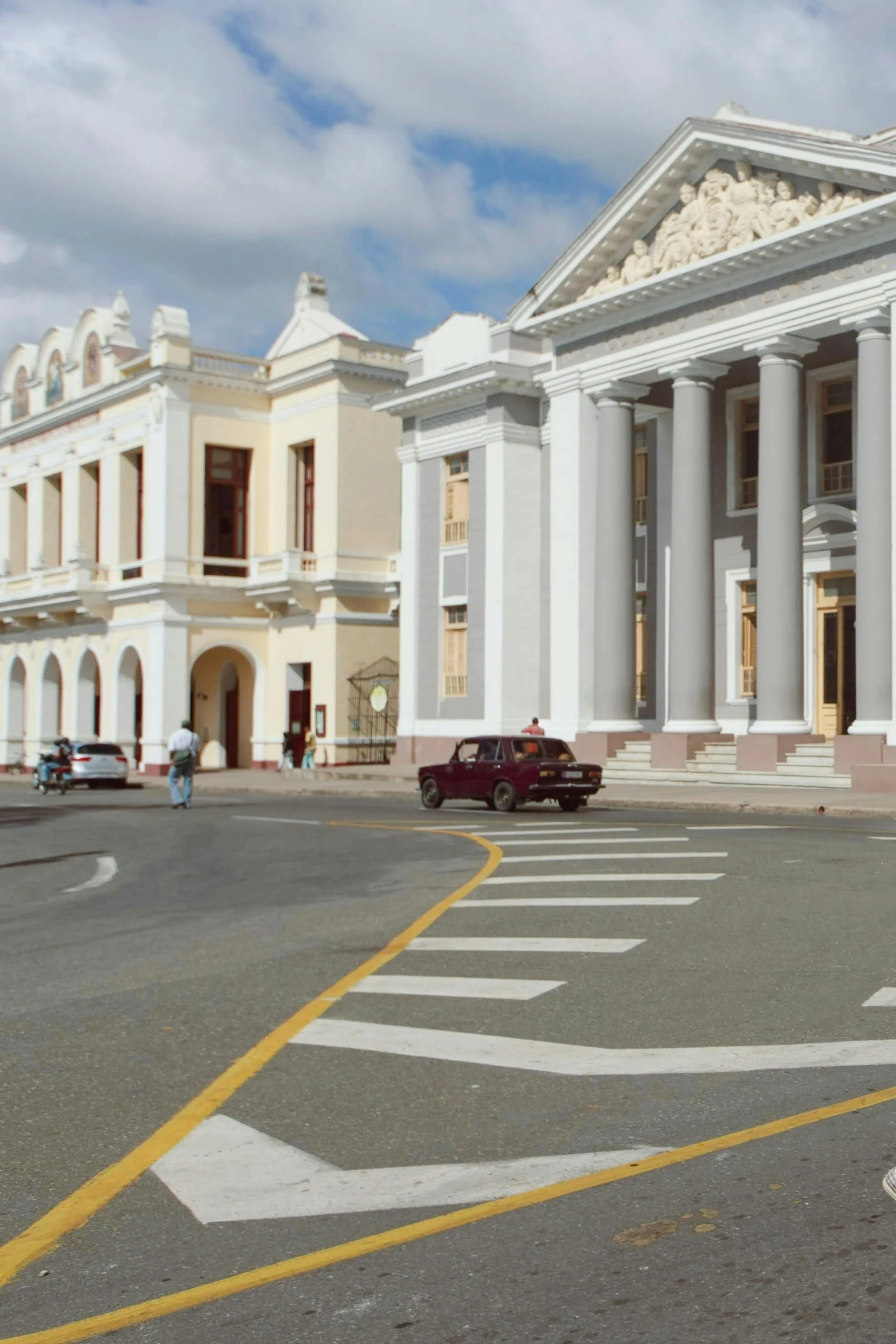 cars are parked in front of the grand white building