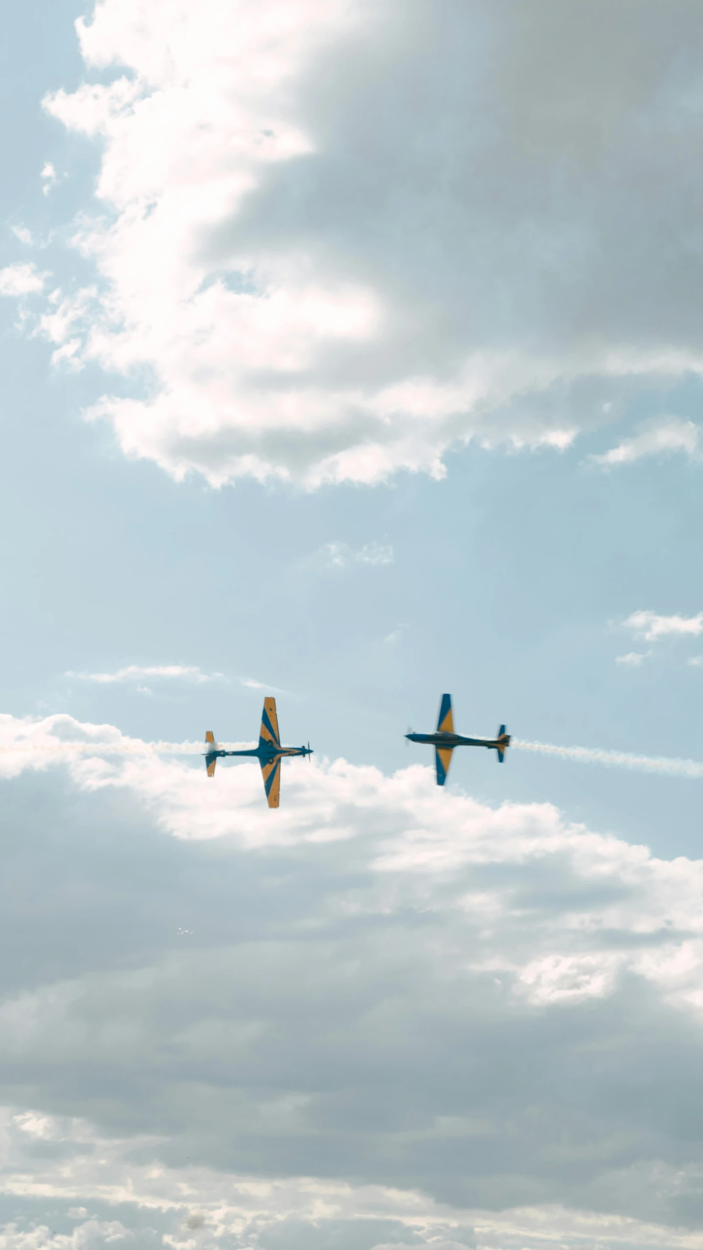 two airplanes fly through a cloudy sky